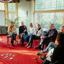 Mensen die in een kring rond het spel zitten Mensen die in een kring rond het spel zitten